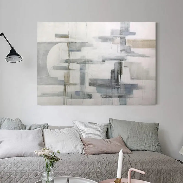 A vibrant abstract painting adorns the wall above a pristine white couch.