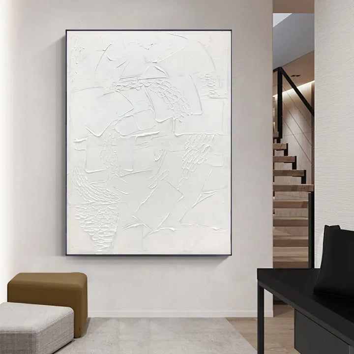 A white abstract painting hangs above a staircase, adding a touch of elegance to the space.