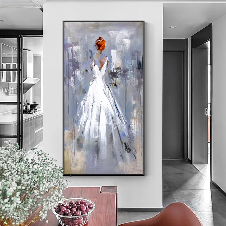 A woman in a white dress stands in a modern kitchen, surrounded by contemporary appliances and decor.