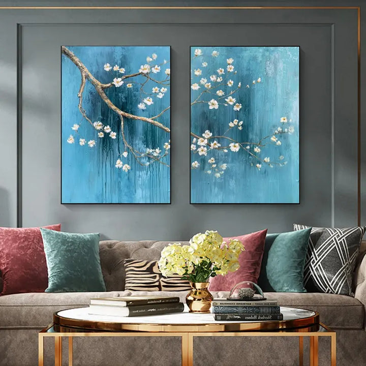 Two blue flower paintings hanging on a wall, showcasing delicate petals and vibrant hues.