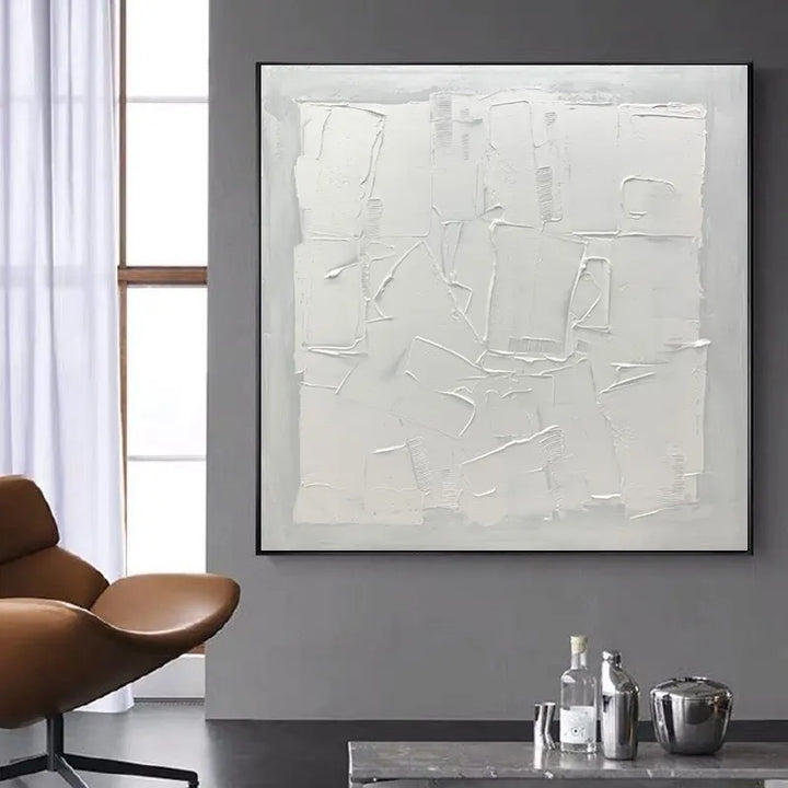 A white abstract painting adorns a living room, adding a touch of elegance and artistic flair.