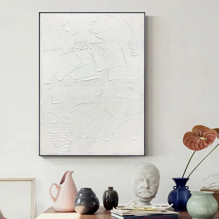 A white abstract painting hanging above a table, adding artistic flair to the room's decor.