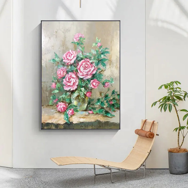 A beautiful painting of pink roses in a vase, displayed on a wall.