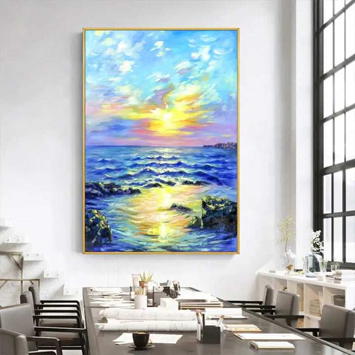 A modern office with a painting of the ocean and sunset, creating a serene and calming atmosphere.